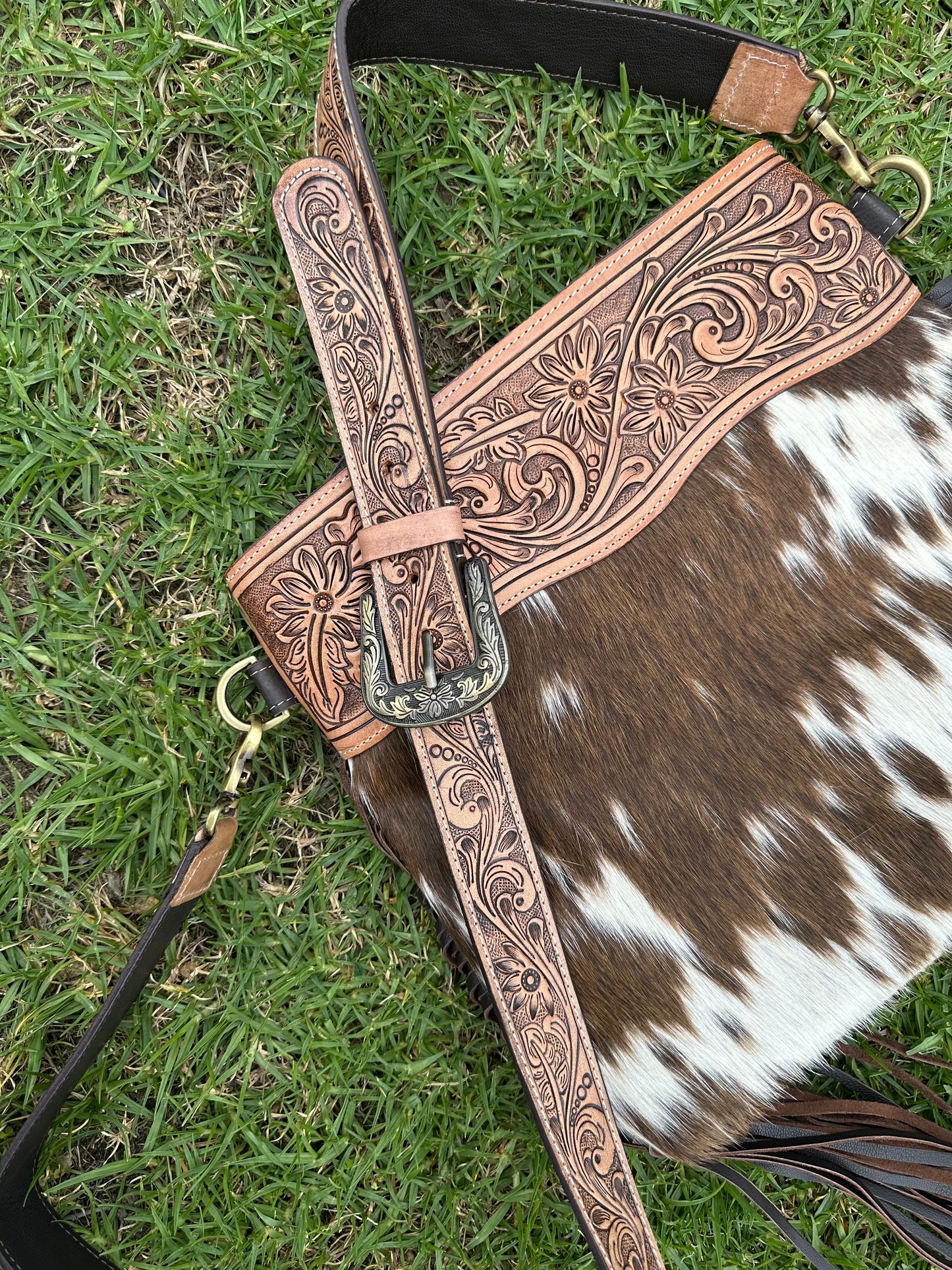 large cowhide bag with tooled shoulder strap 