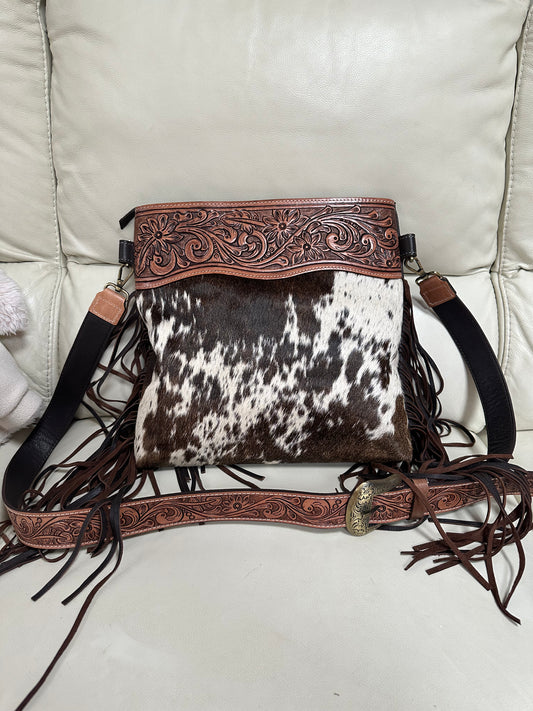 large cowhide bag with tooled shoulder strap